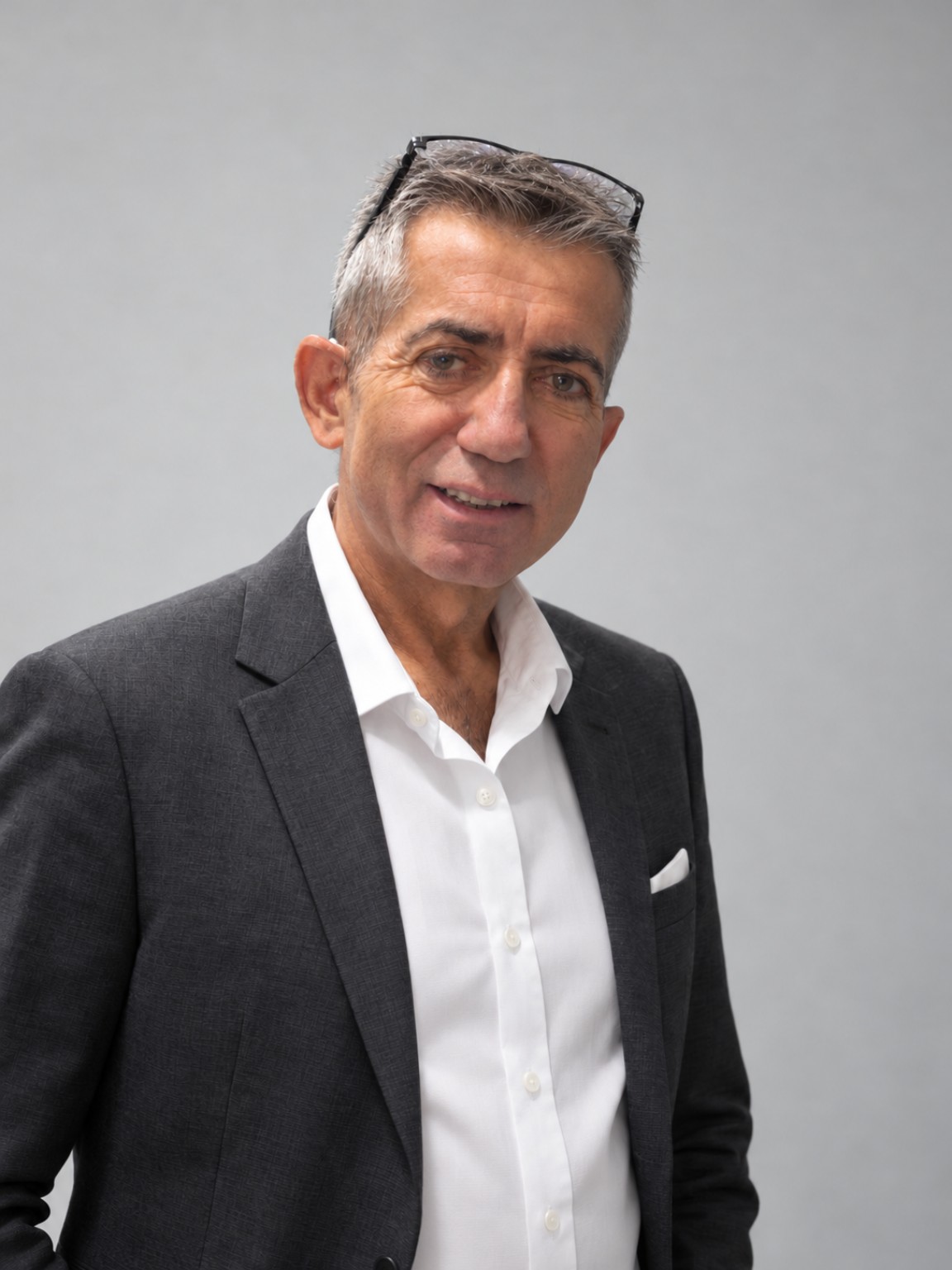 Fatih Özbay, koyu renk ceket ve beyaz gömlekle